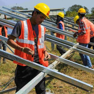 A ground-mounted solar module mounting structure supporting a row of solar panels in a solar farm.