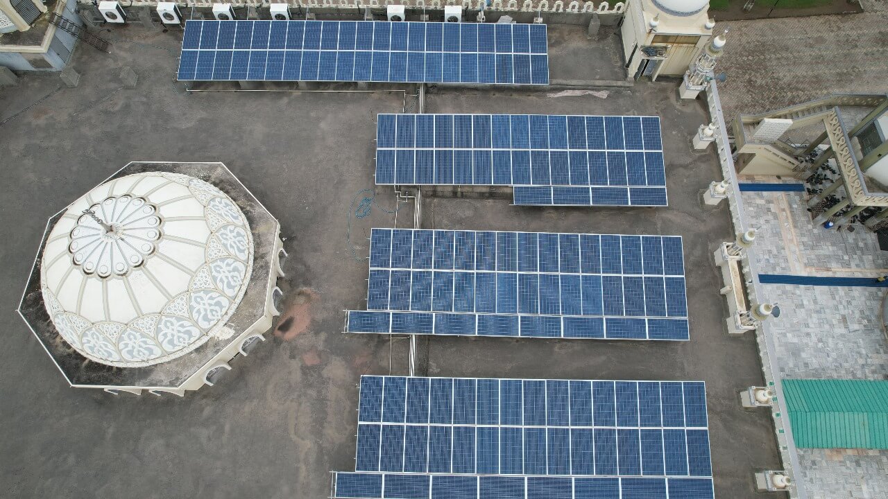 Aerial shot of rooftop solar panels beside an Madrasa Jamia Islamia on a flat building